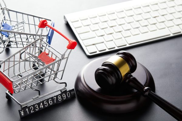 A high angle view of the judge gavel, shopping baskets, and a keyboard - World Consumer Rights Day